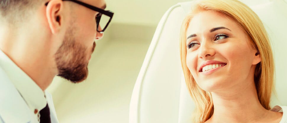 Dentist talking to smiling patient