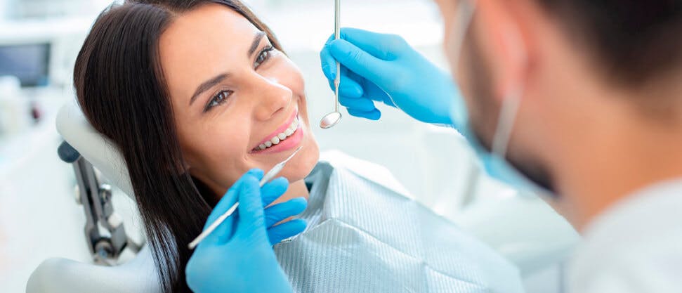 Dentist holding tools up to a patient’s mouth