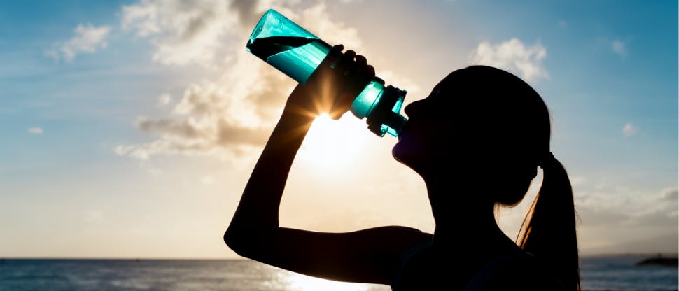 Active woman drinking water