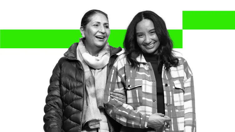 Dos mujeres sonriendo y caminando de la mano 