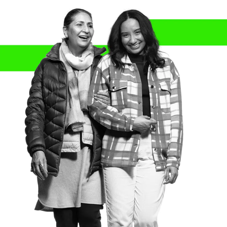Dos mujeres sonriendo y caminando de la mano 