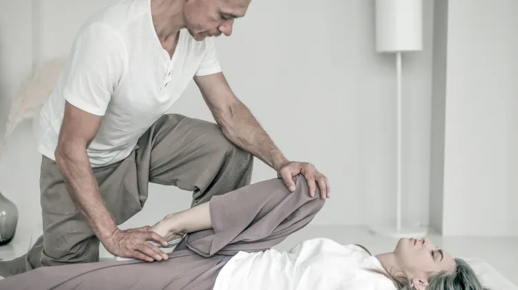 Fisioterapeuta ayudando al paciente a estirarse 