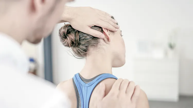 Fisioterapeuta realizando estiramiento de cuello en el paciente 