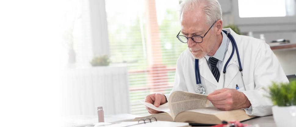 Un doctor leyendo un libro de medicina