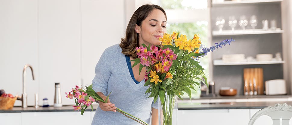 Mujer oliendo flores