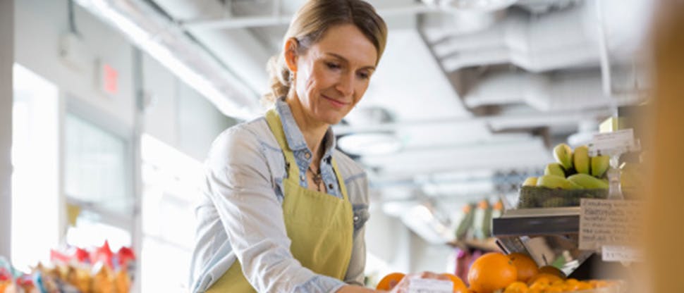 Señora con delantal trabajando en un puesto del mercado