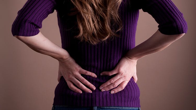 Mujer agarrándose la zona lumbar de la espalda