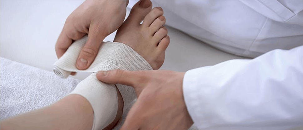 Doctor ayudando a paciente con tobillo lastimado