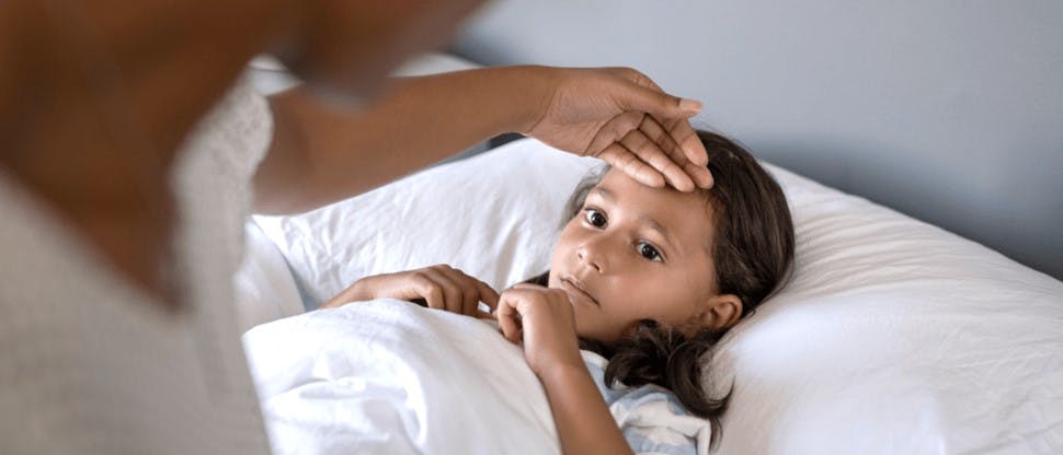Foto de niña con fiebre en cama