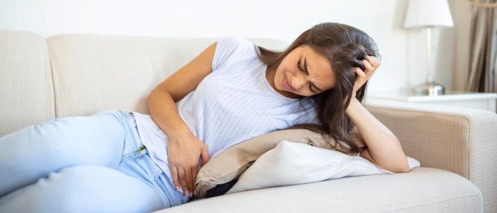 Mujer en sillón con dolor menstrual