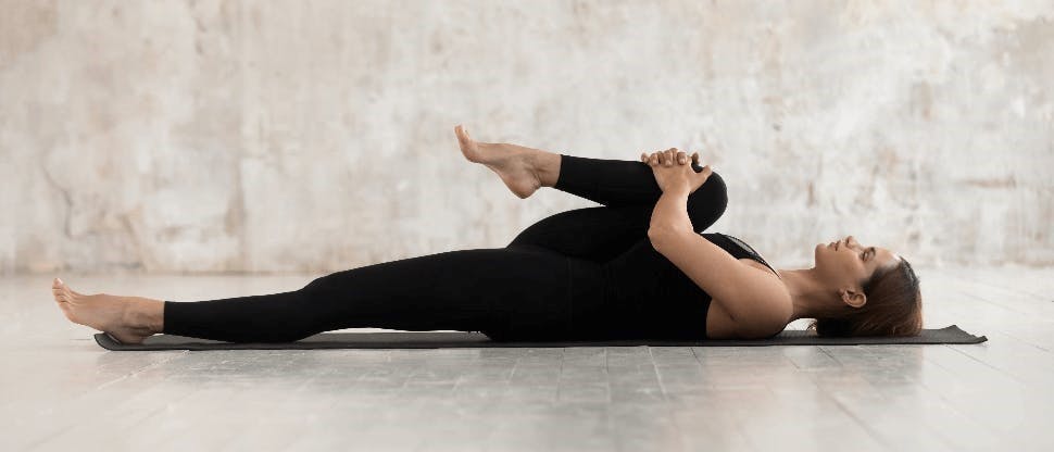Mujer estirando en tapete de yoga