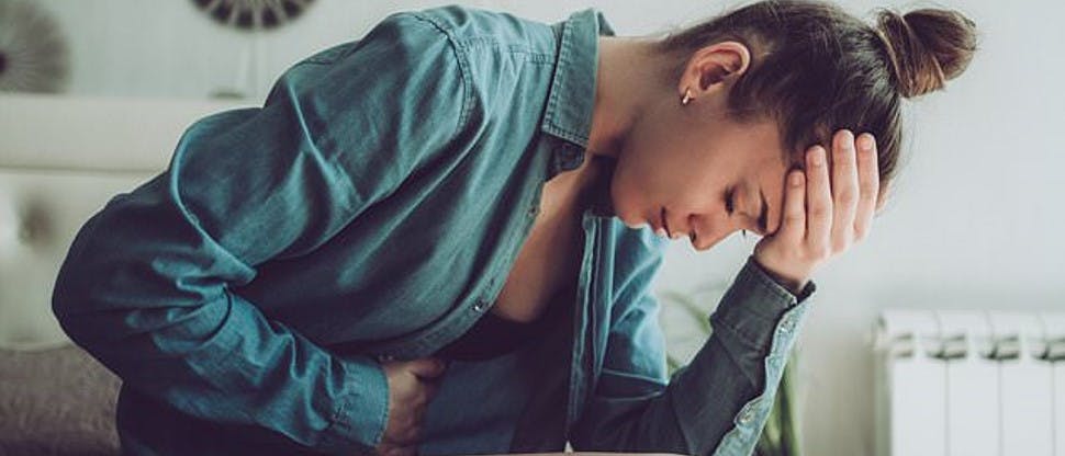 Mujer tocándose la cabeza con dolor menstrual