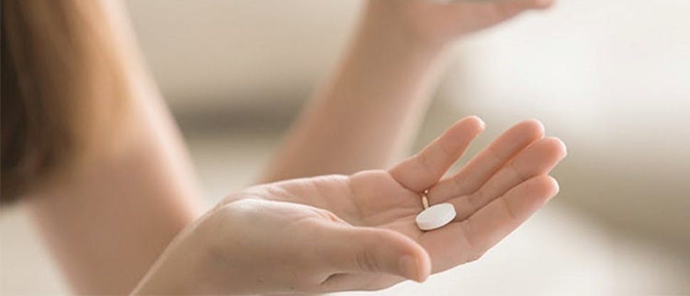 Mujer tomándose una tableta