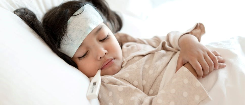 Niña con fiebre en cama