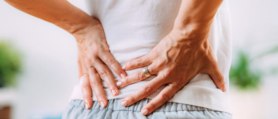 Persona con manos en la espalda