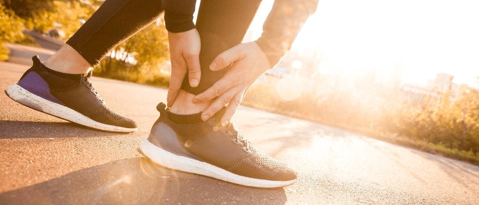 Persona tocándose el tobillo