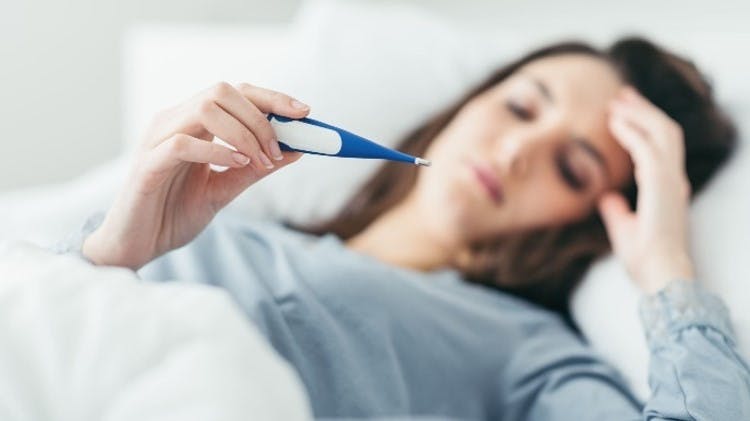 Foto mujer en cama con termometro