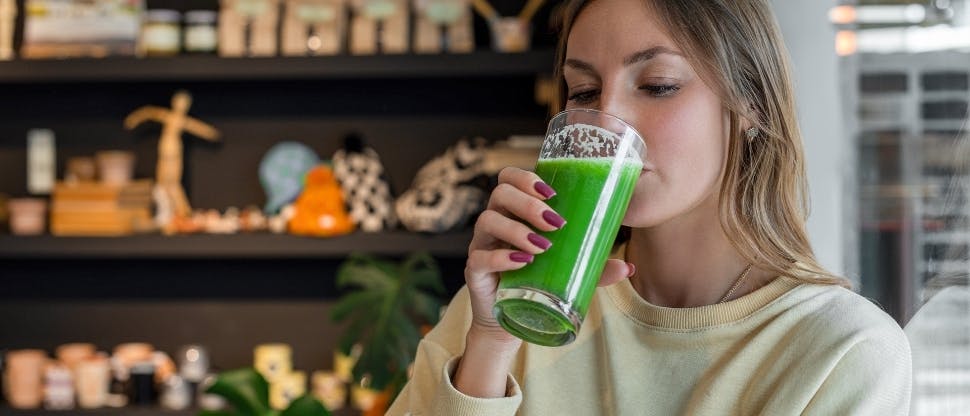 Mujer tomando un jugo verde