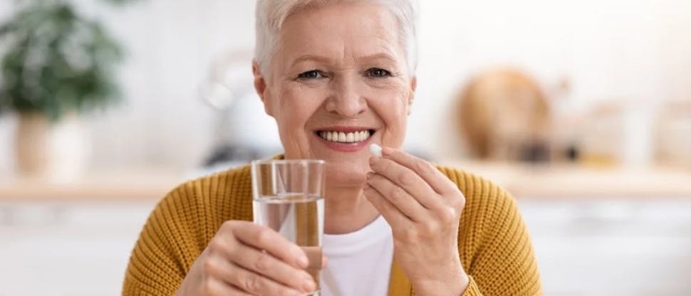 Adulto mayor tomando un multivitaminico