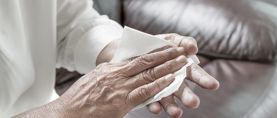 Personne s’essuyant les mains avec un essuie-tout.