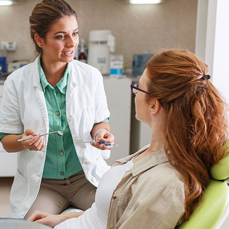 Dentiste parlant à sa patiente