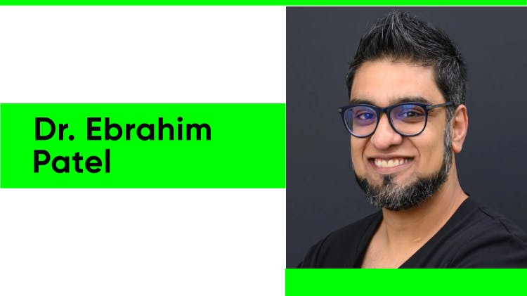 Portrait du Dr Ebrahim Patel, un homme asiatique aux cheveux noirs courts et à la barbe foncée. Il sourit largement tout en portant un T-shirt noir et une montre bleue