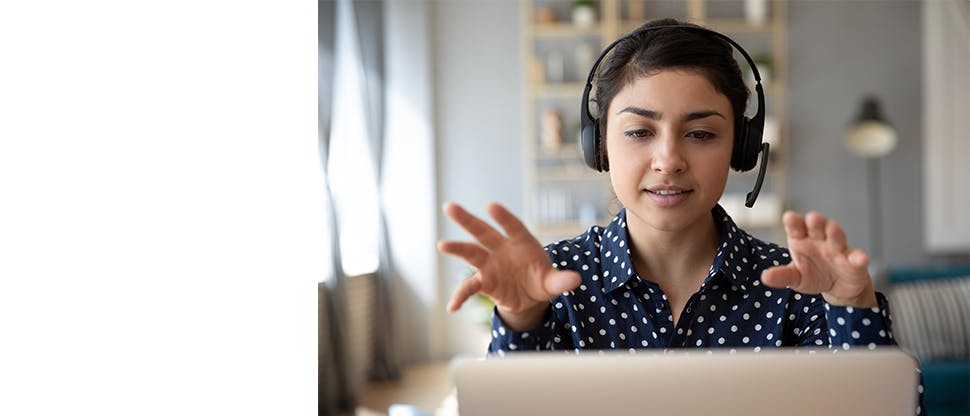 Femme portant un casque d'écoute parlant à un écran d'ordinateur