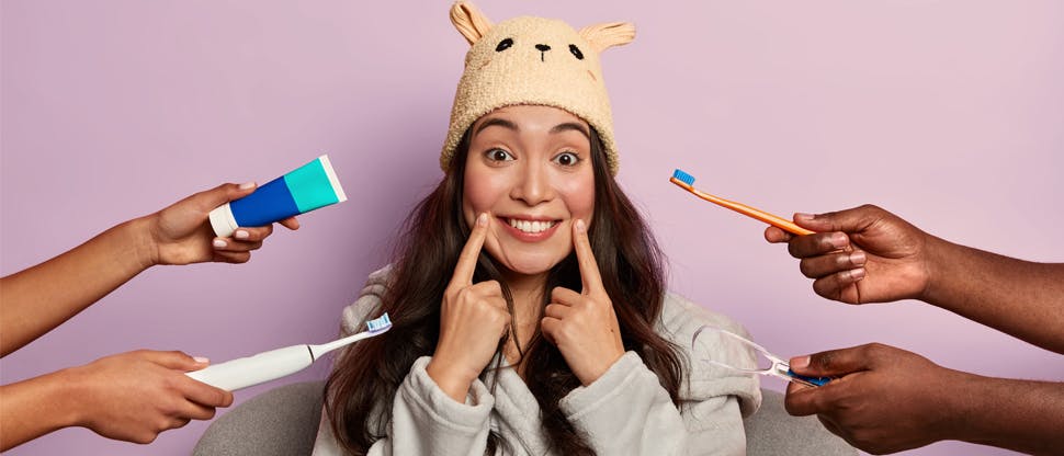 Mosolygó nő szájápolási termékekkel körülvéve