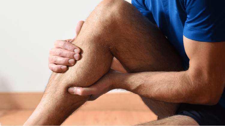 Férfi szorítja a vádliját