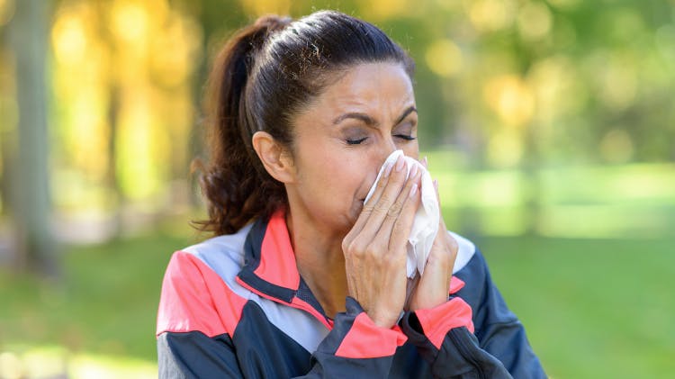 Kobieta doświadczająca letnich alergii dmucha nos