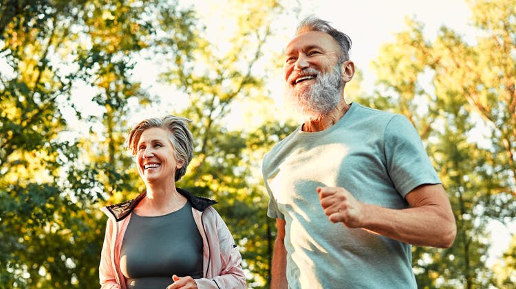 Starsza para biegnąca przez park