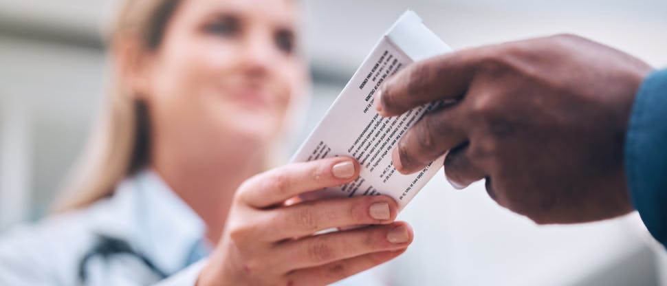 Farmaceuta podający opakowanie rutinoscorbin pacjentowi