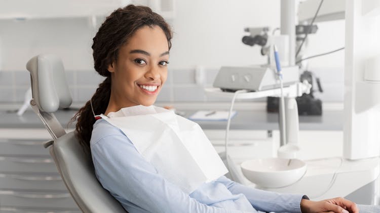 Dentista com óculos sorrindo para a câmera