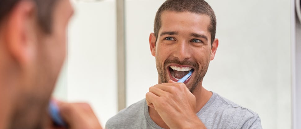 Homem escovando os dentes