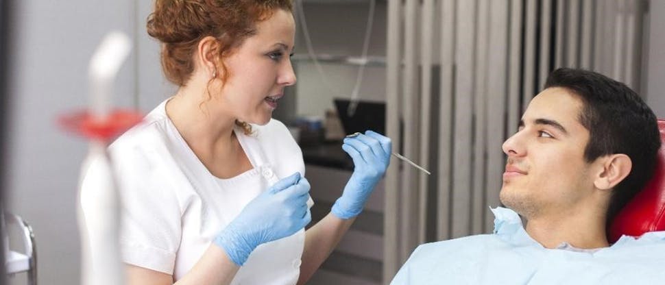 Dentista falando com paciente