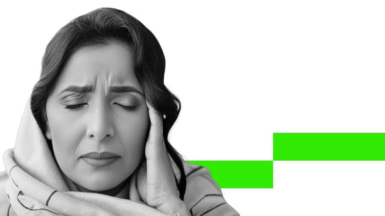 Mulher de cabelos escuros usando cachecol tocando a têmpora com expressão de dor