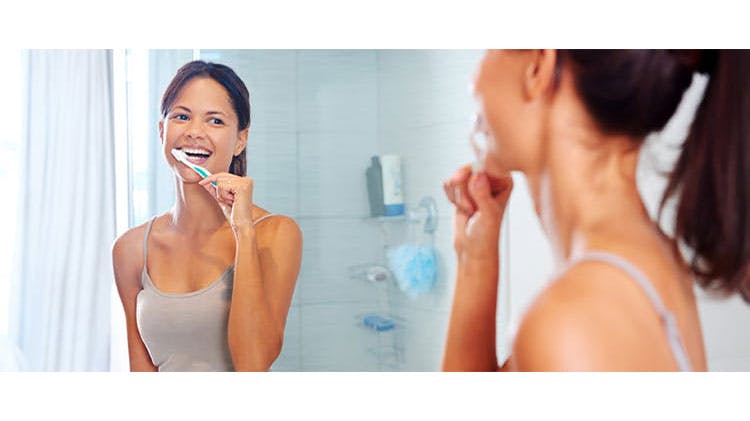 Женщина во время чистки зубов