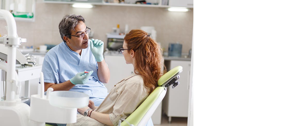 Tandläkare diskuterar med patient