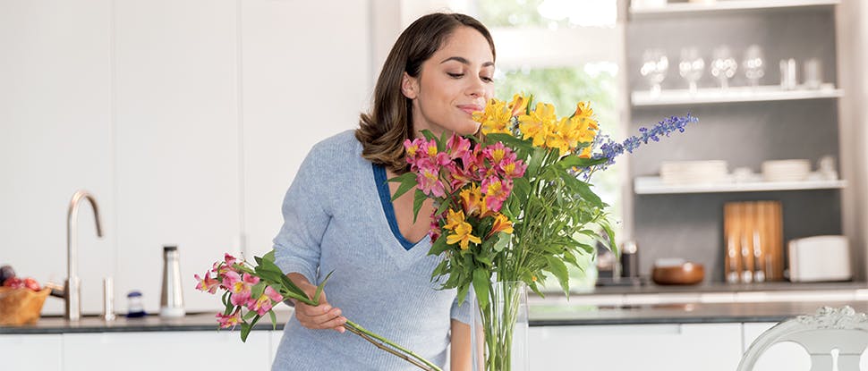 Çiçekleri koklayan kadın
