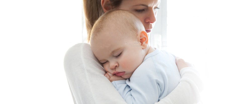 Жінка тримає сплячу дитину на руках