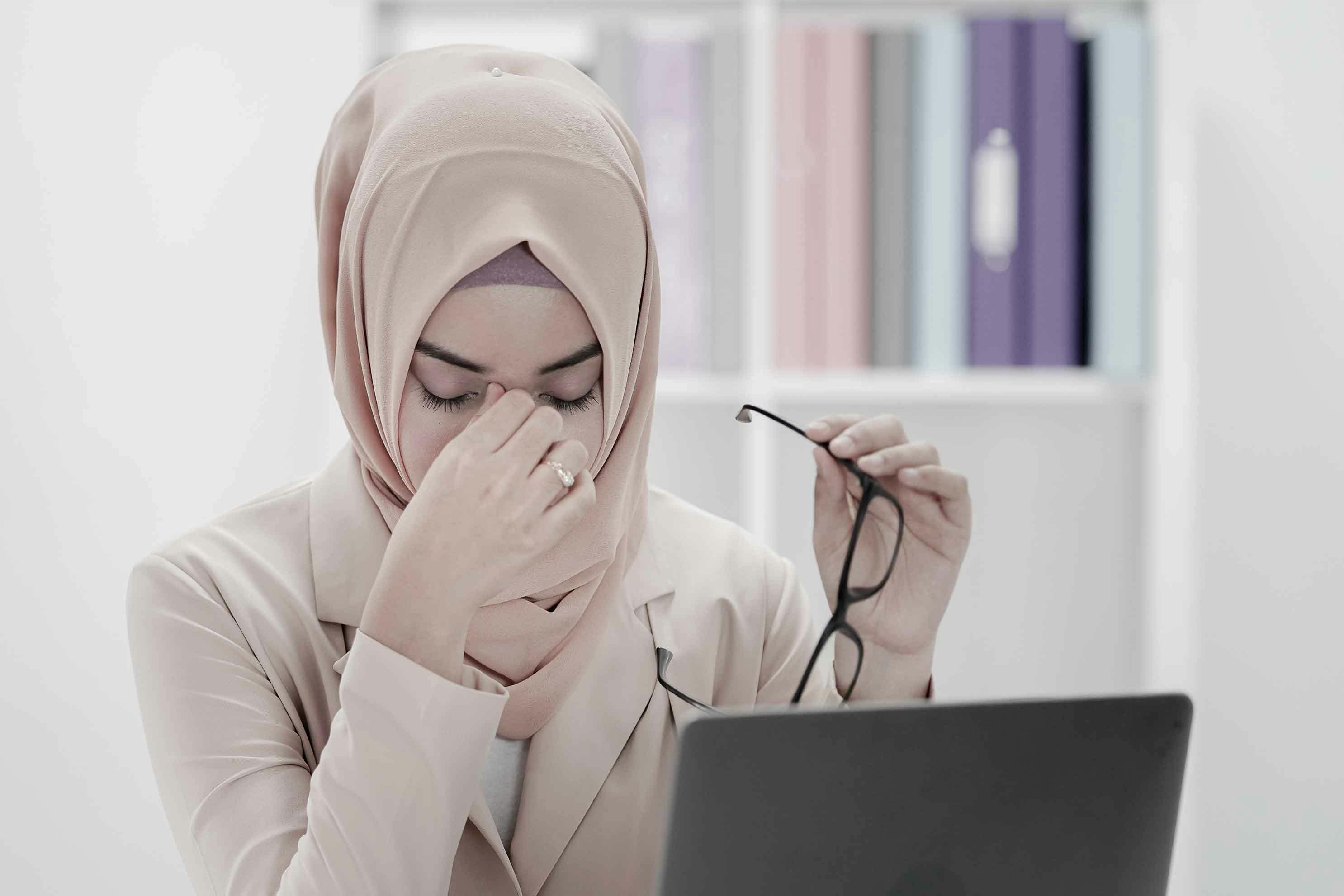Stressad kvinna som arbetar på en bärbar dator