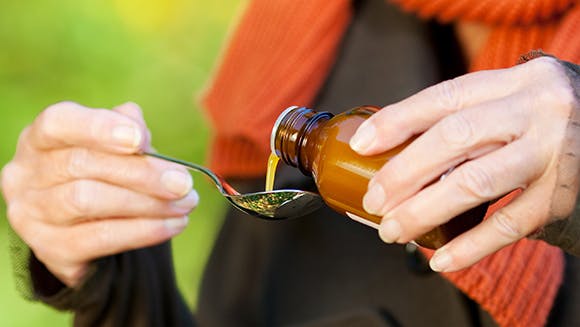 Lady pouring cold and flu syrup