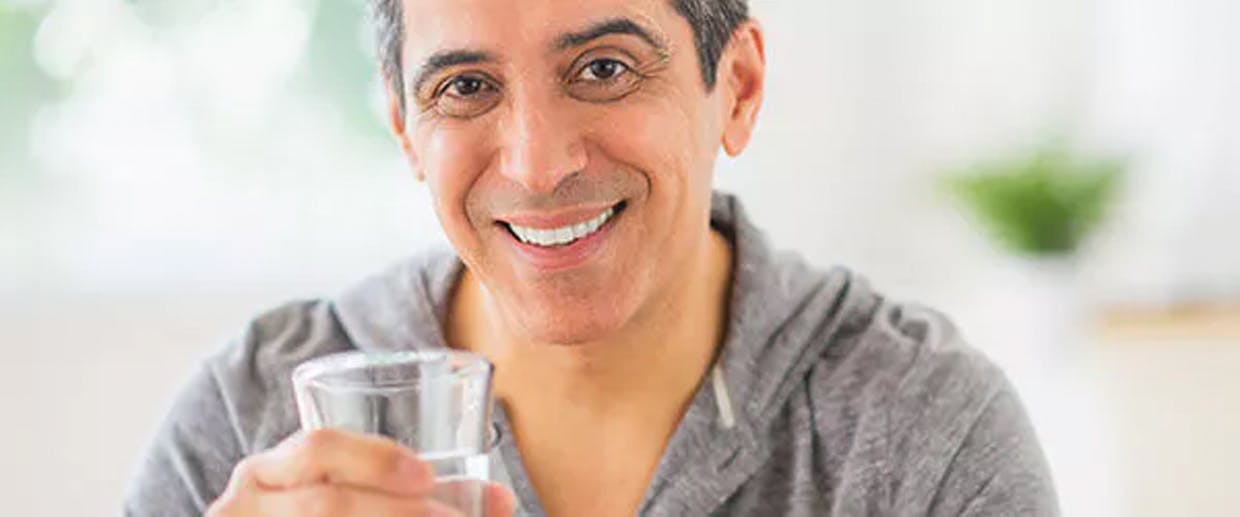 Homme qui a un verre d’eau à la main