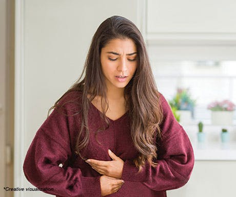 Young woman holding her stomach in pain
