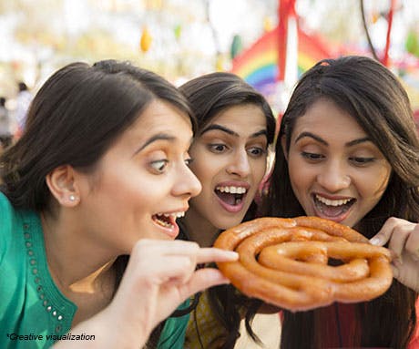 Three girls eating a jalebi
