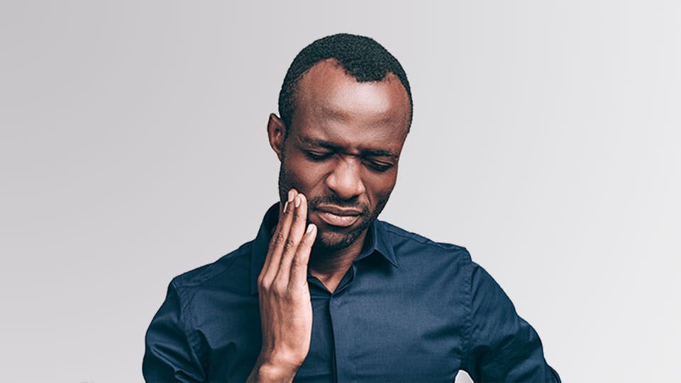 Young man holding his jaw from tooth pain. 