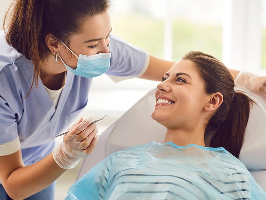 Female Dentist Conducting an Exam on a Smiling Female Patient