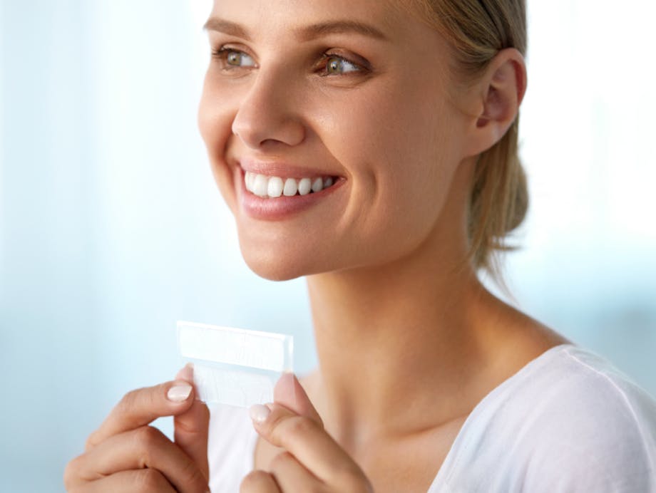 woman holding whitening strips