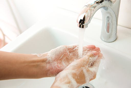 Eine Person wäscht sich die Hände, um gute Hygiene zu gewährleisten und Erkältung und Grippe zu vermeiden.