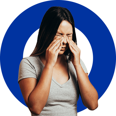 A woman rubs her nose because of sinusitis, an inflammation that usually comes from a cold.